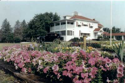 Image of restored farmhouse and old car